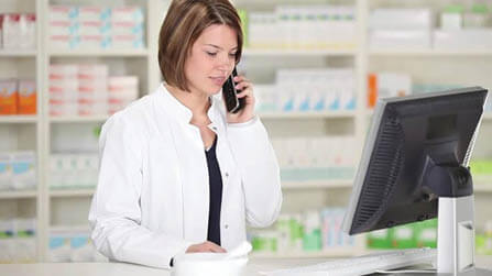 Pharmacist on telephone in front of screen